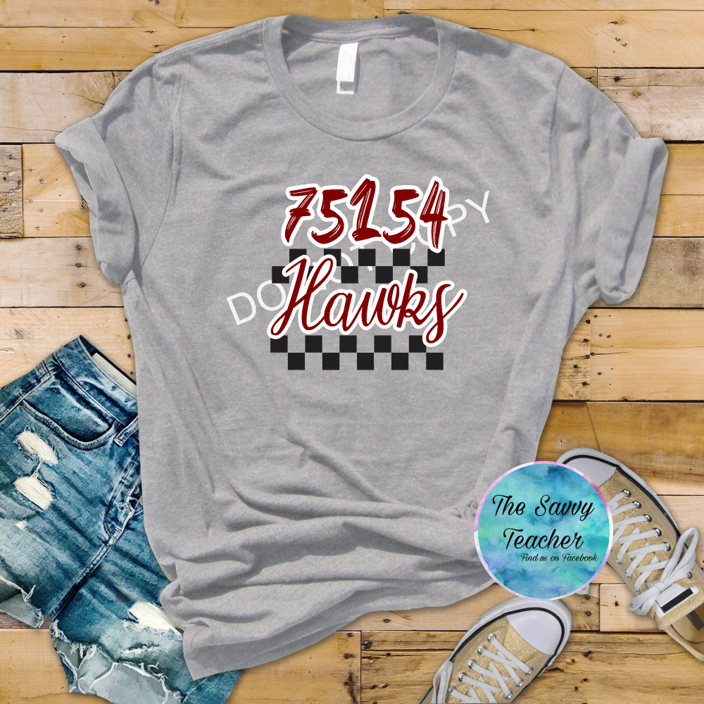 Gray t-shirt with '75154 DO Hawks' design on a wooden floor with shorts and sneakers.