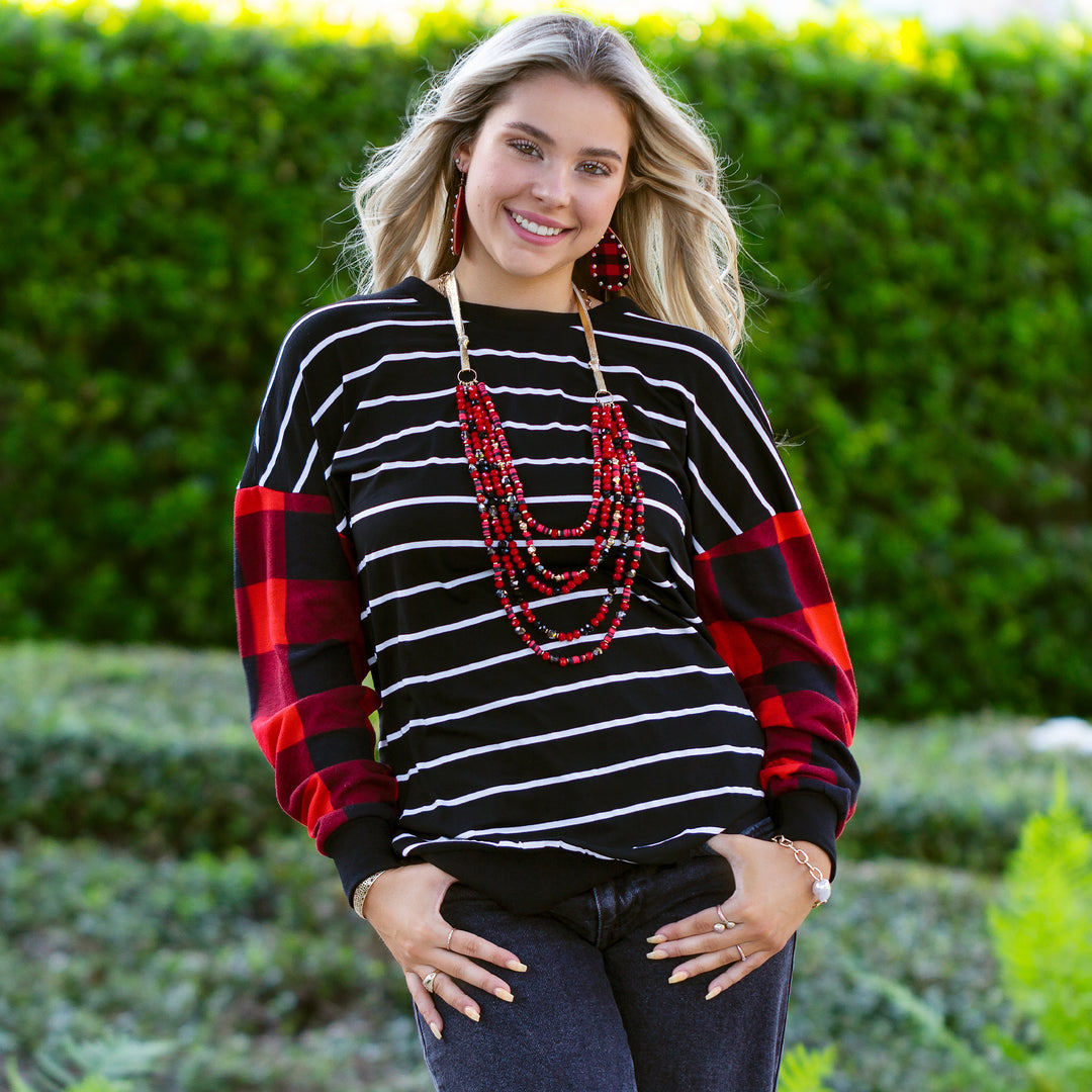 black striped light sweater with red plaid sleeves