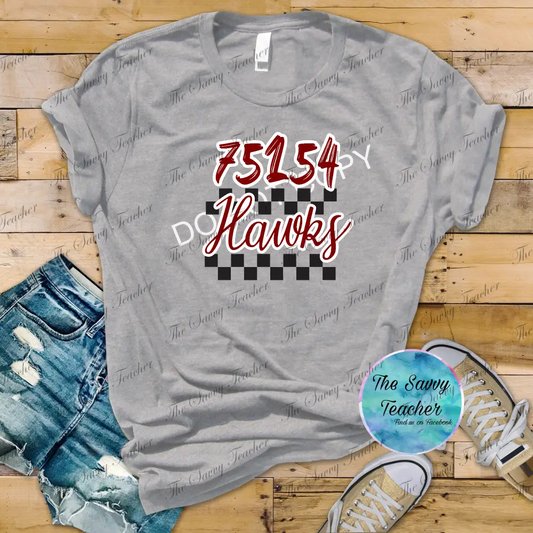 Gray t-shirt with '75154 DO Hawks' design on a wooden floor with shorts and sneakers.