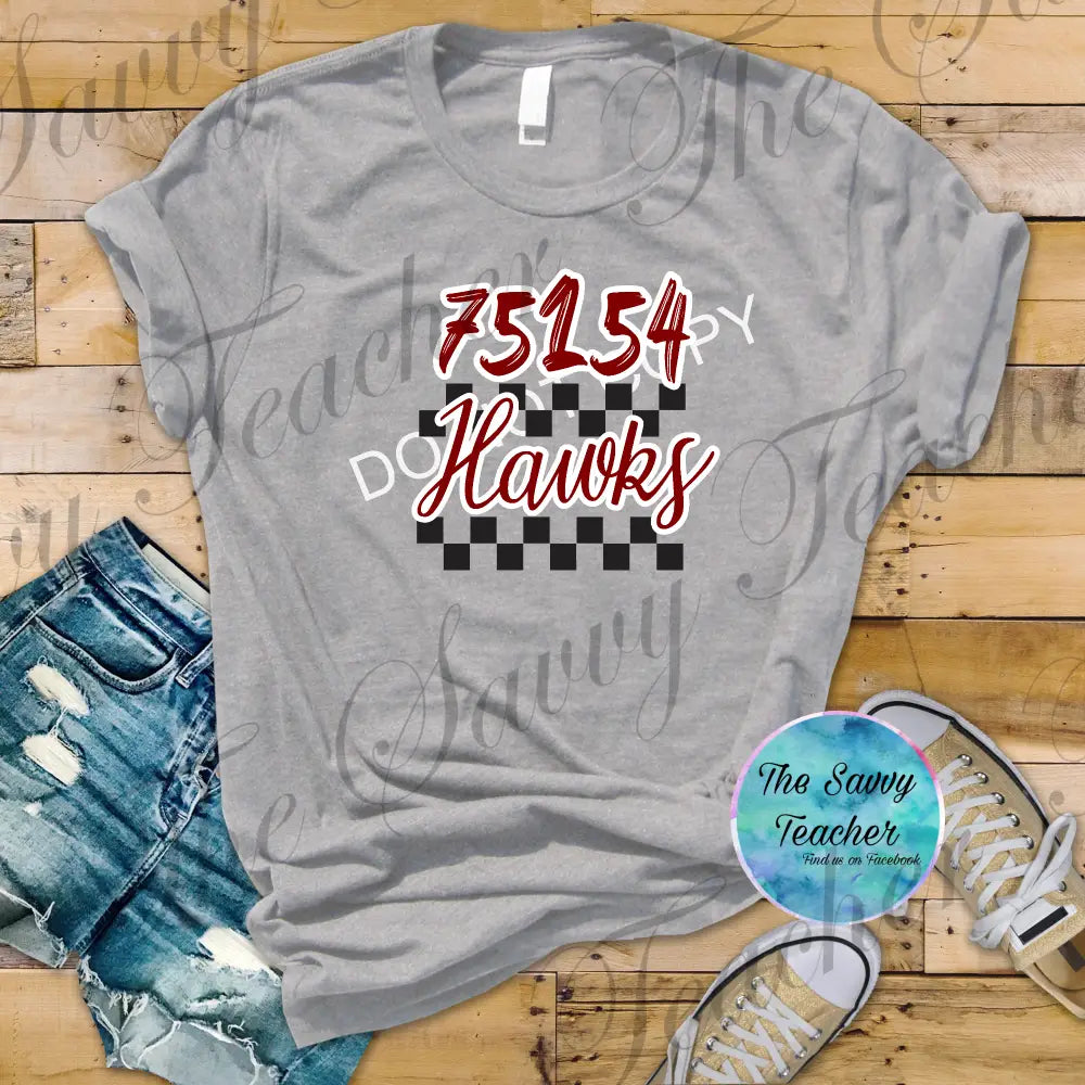 Gray t-shirt with '75154 DO Hawks' design on a wooden floor with shorts and sneakers.